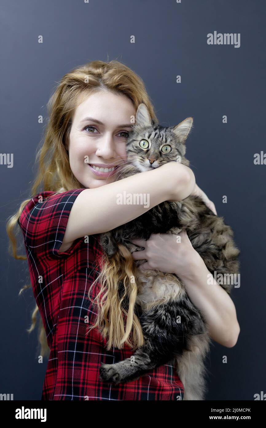 Mädchen umarmt eine gestreifte, überraschte Katze. Liebe für Katzen. Katzen sind Glück Stockfoto