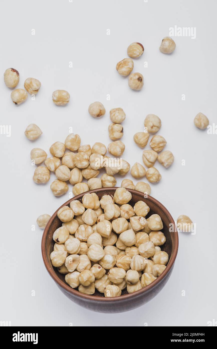 Haselnüsse verschüttet in der Nähe der Schüssel Stockfoto
