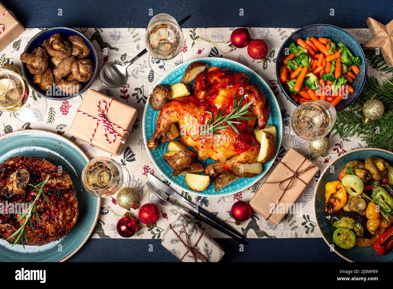 Weihnachtliche Tischansicht mit Essen, Wein und Geschenken Stockfoto