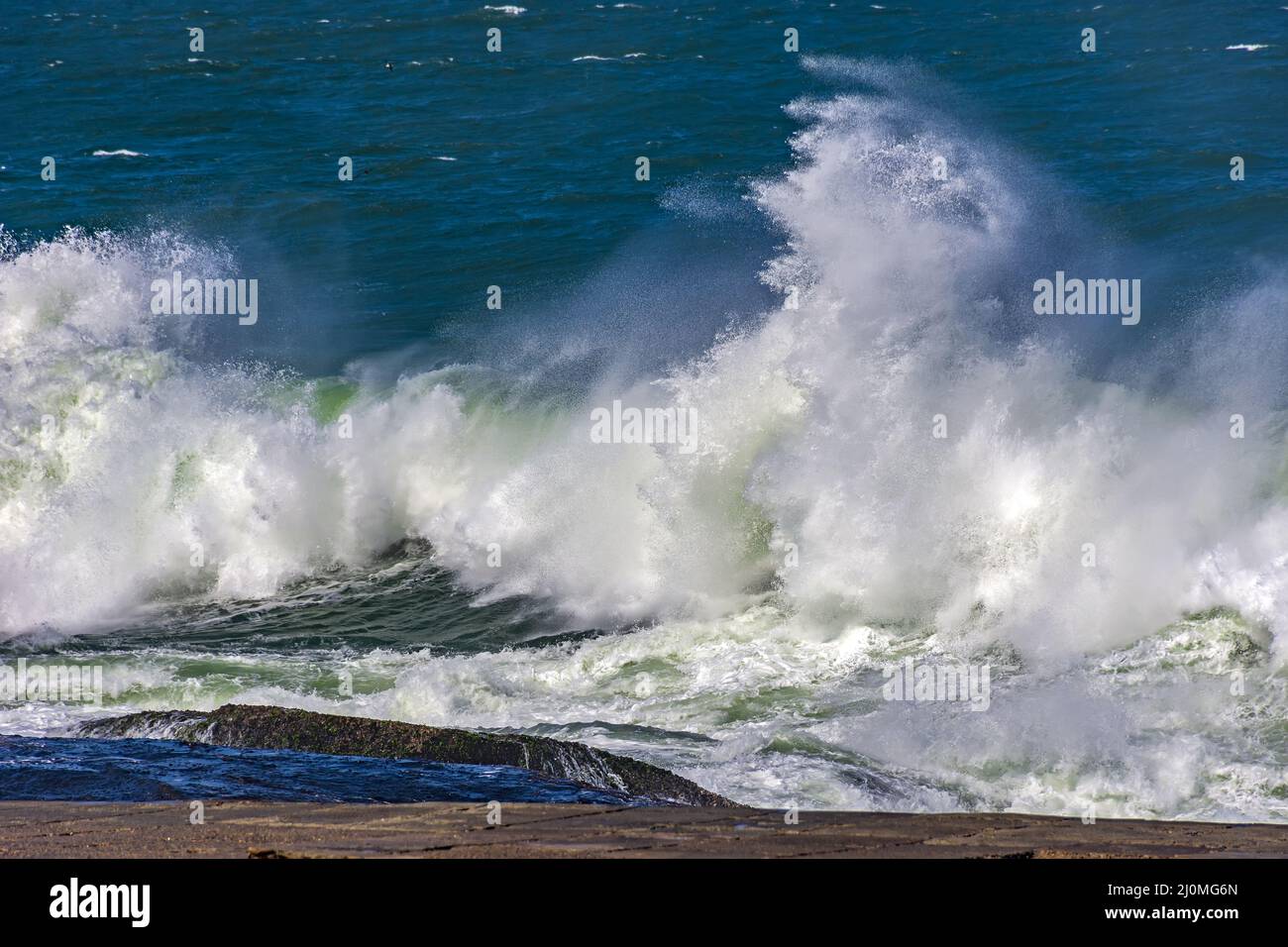 Starke Wellen krachen gegen Felsen Stockfoto