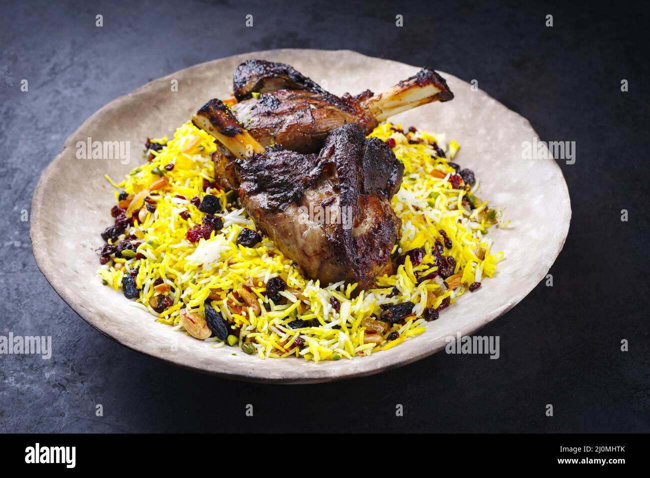 Traditioneller persischer Tahdig-Javaher Polow-Braut-Basmati-Reis mit langsam gekochtem Lammschenkel, der als Nahaufnahme auf einem rustikalen d serviert wird Stockfoto