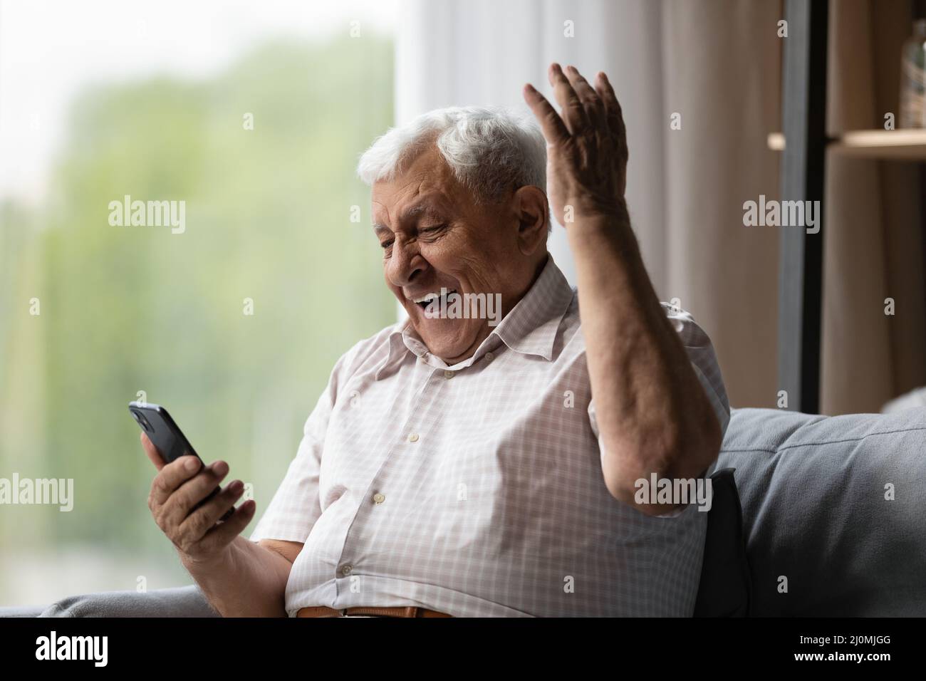 Älterer Mann schaut auf Handy, lesen unglaubliche Nachrichten fühlt sich aufgeregt Stockfoto