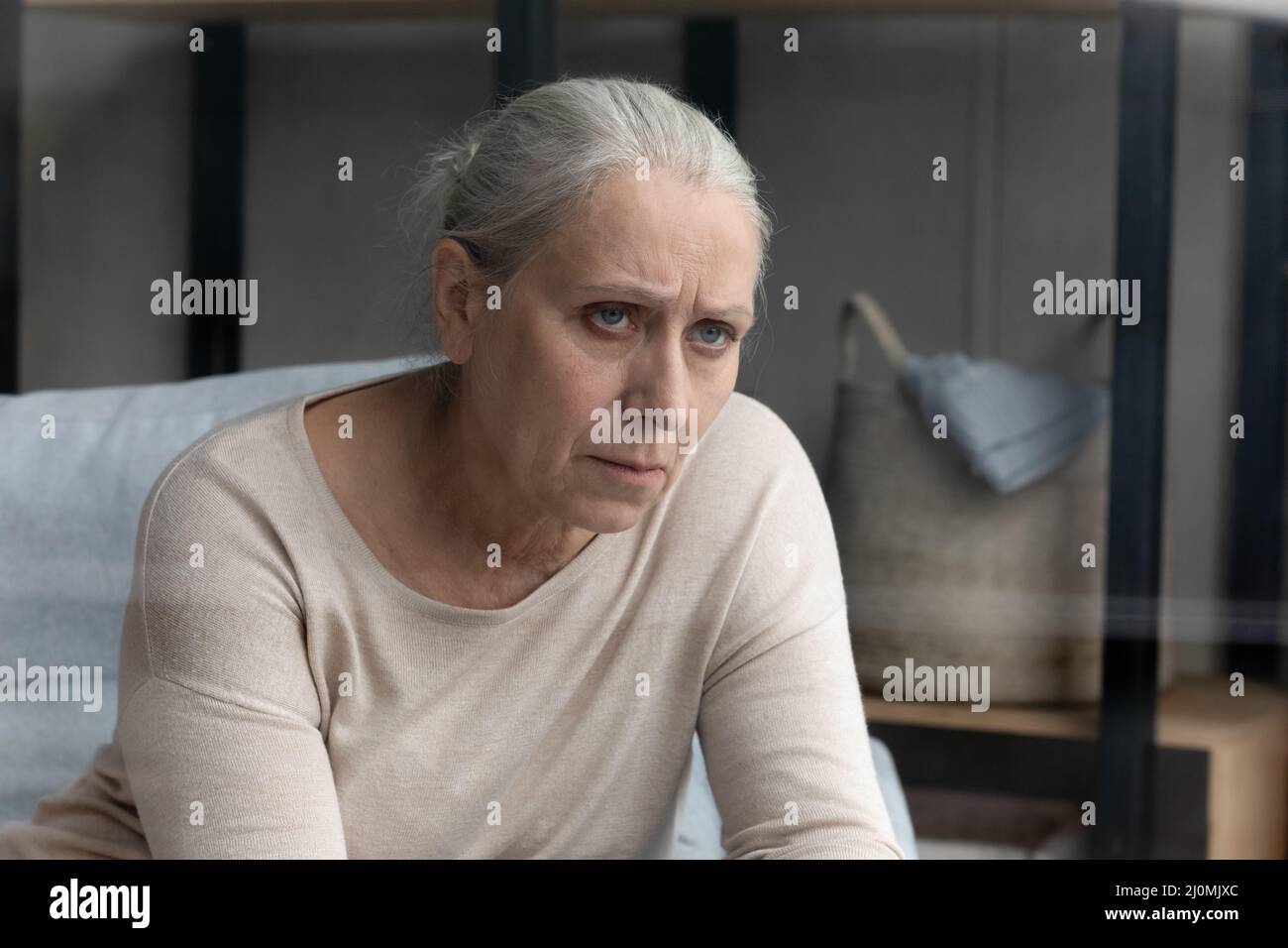 Pessimistisch gealterte Frau, die an einer senilen Krankheit leidet, sieht unglücklich aus Stockfoto