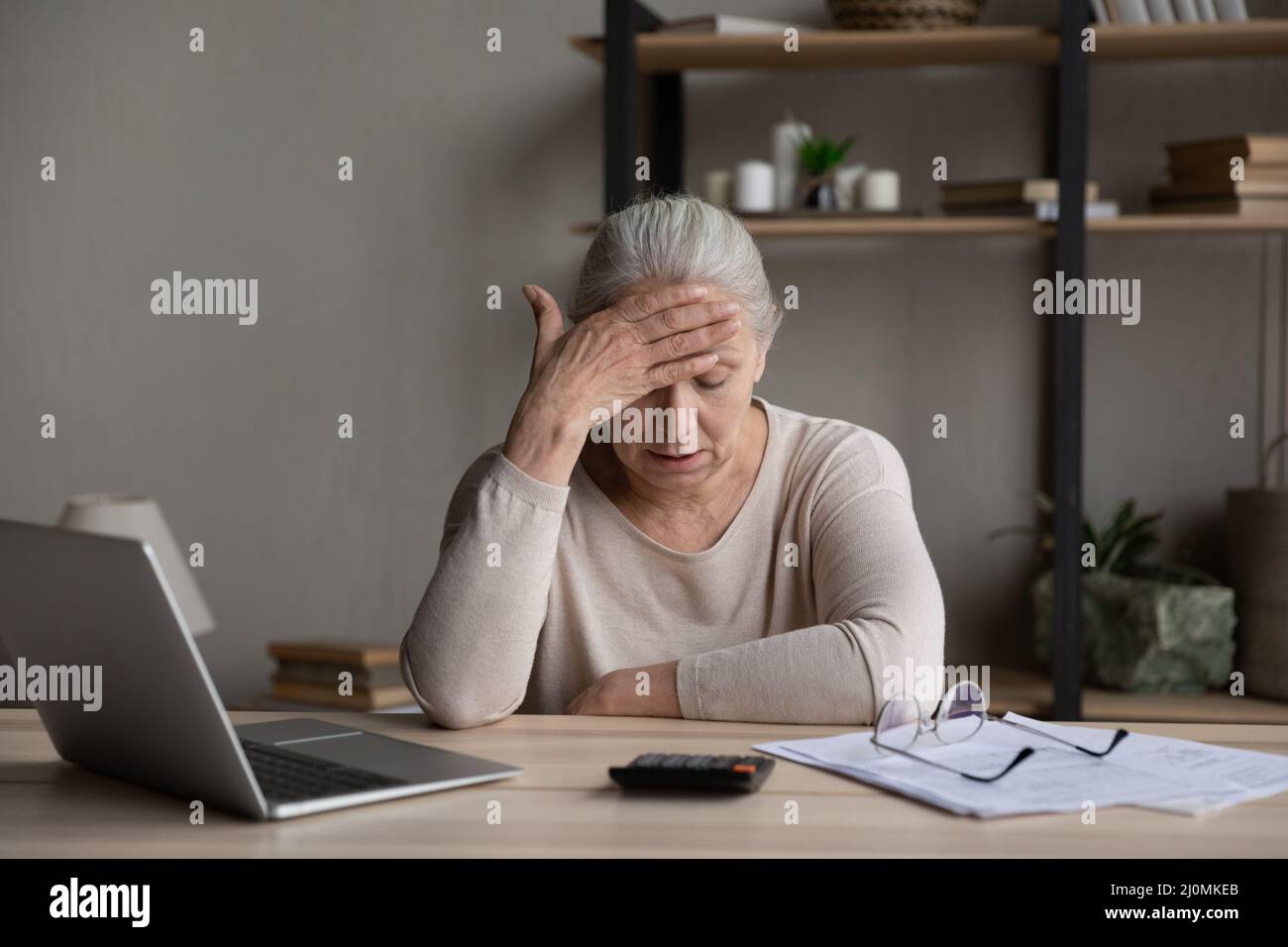 Ältere Frau fühlt sich aufgrund fehlender Geldbezahlung Rechnungen gestresst Stockfoto