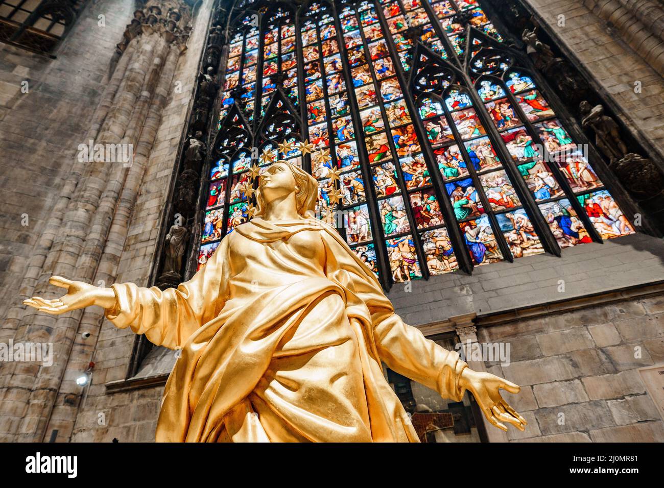 Statue der Madonna in Gold vor dem Hintergrund eines Buntglasfensters im Dom. Mailand, Italien Stockfoto