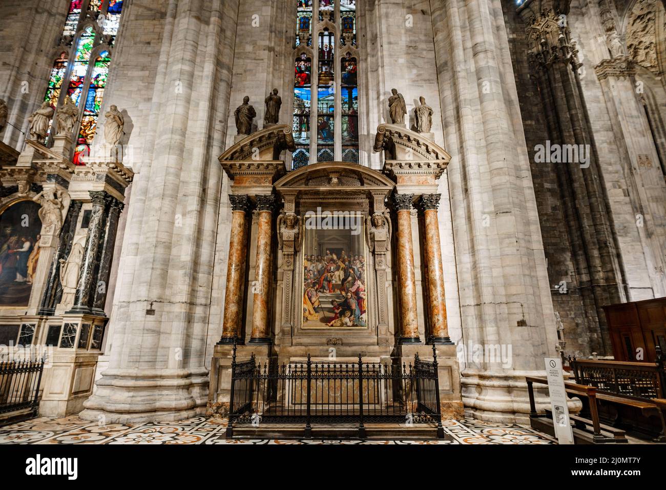 Fresko zwischen den Säulen unter einem Buntglasfenster im Dom. Mailand, Italien Stockfoto