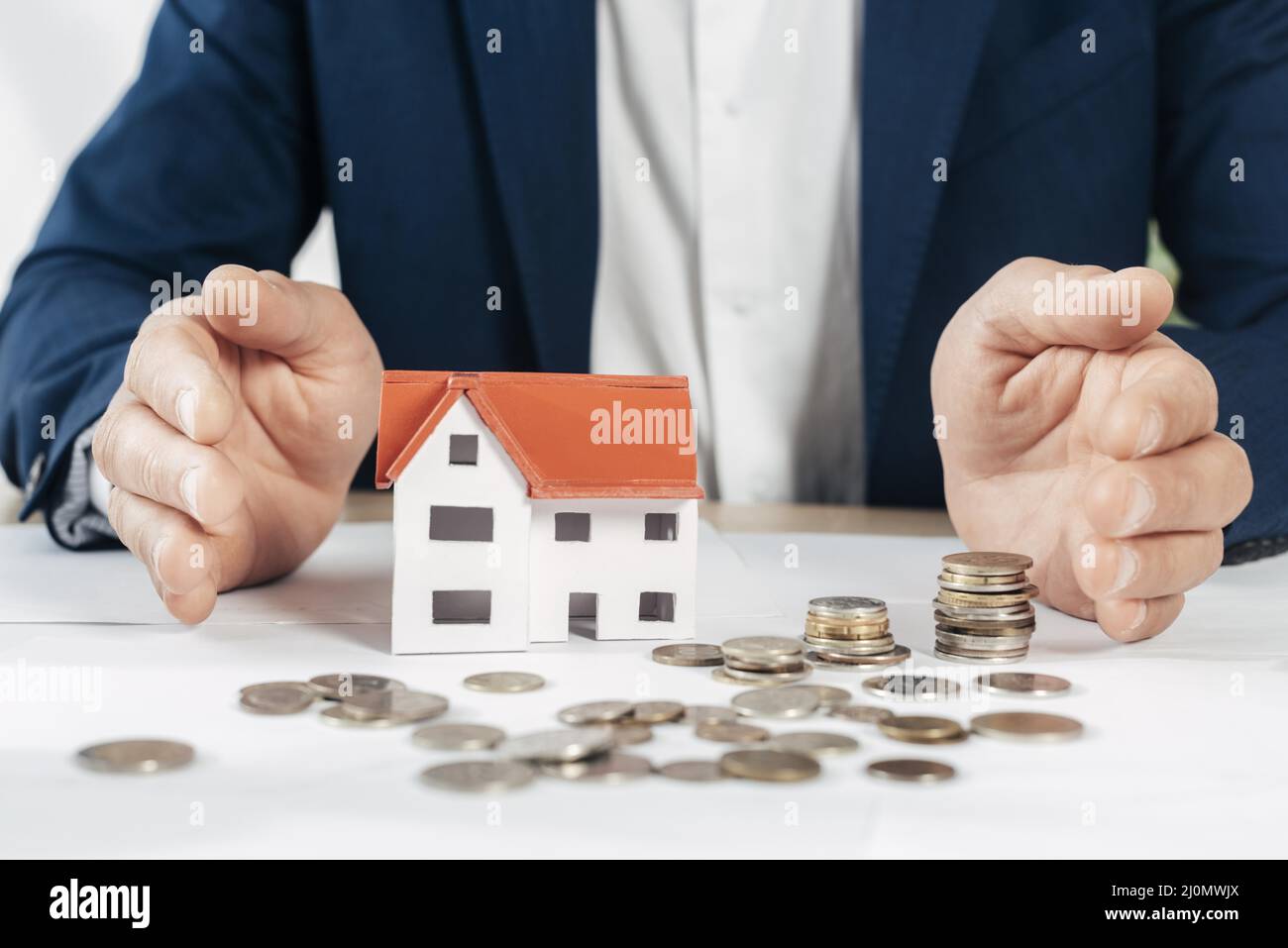 Nahaufnahme der Hände mit dem Münzhaus Stockfoto