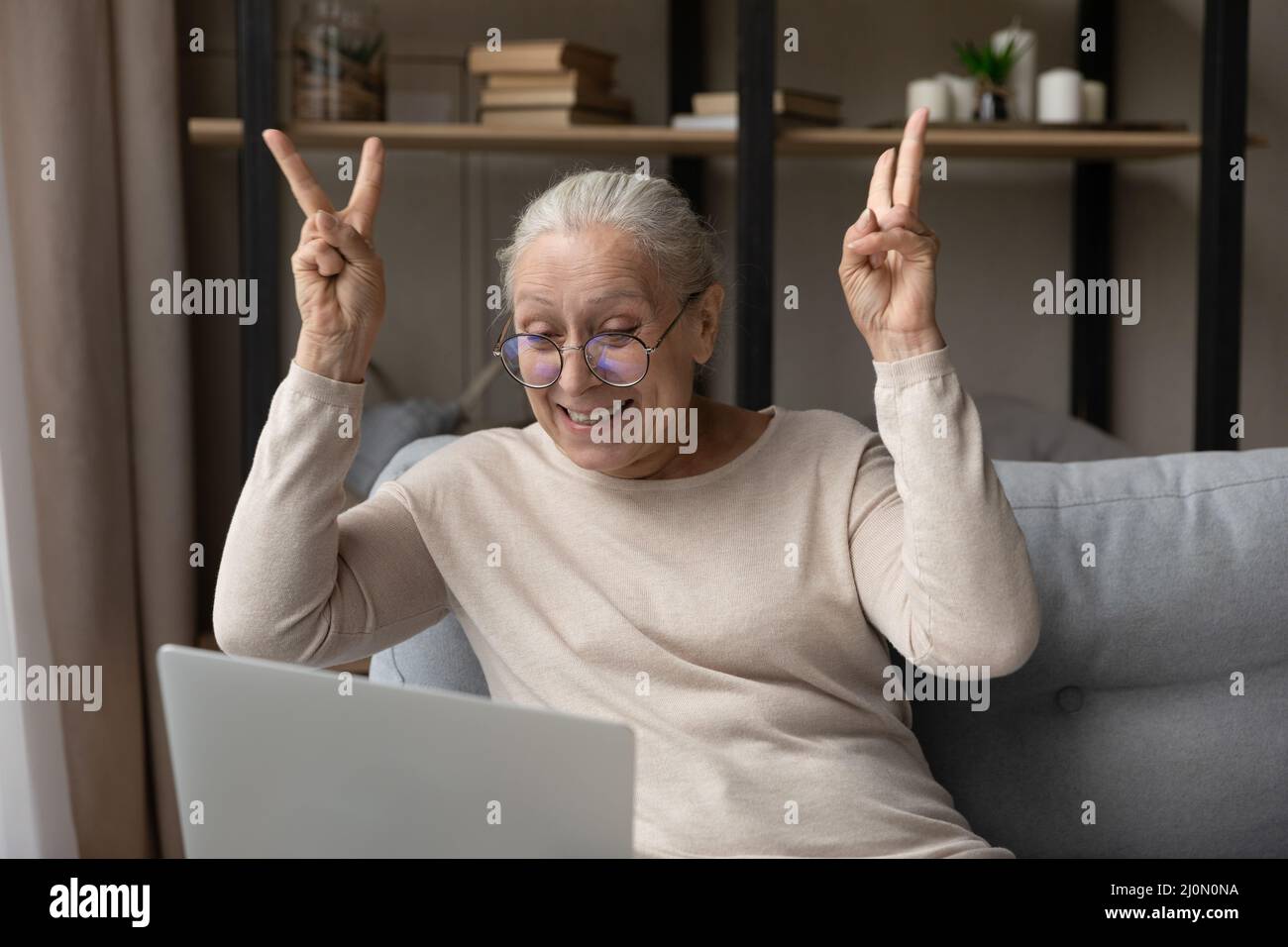 Ältere Frau starrt auf Laptop, gestikulierende Begrüßung Freund macht Videoclip Stockfoto