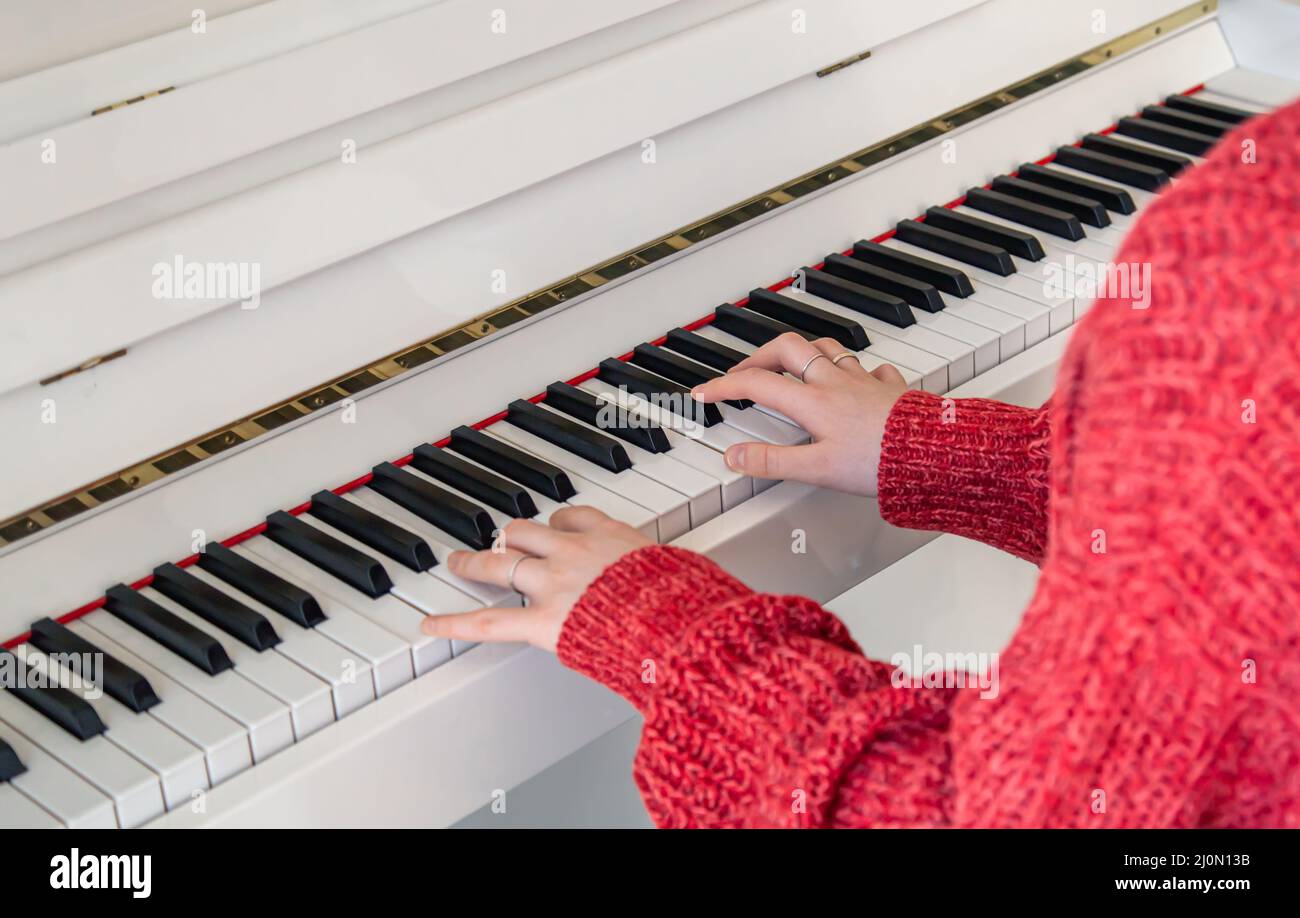 Frauenhand spielt auf einem weißen Klavier, Nahaufnahme. Stockfoto