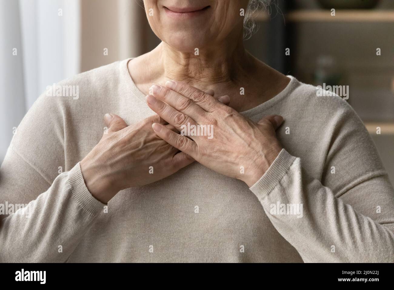 Ältere weibliche legte ihre Hände auf Brust Nahaufnahme Stockfoto