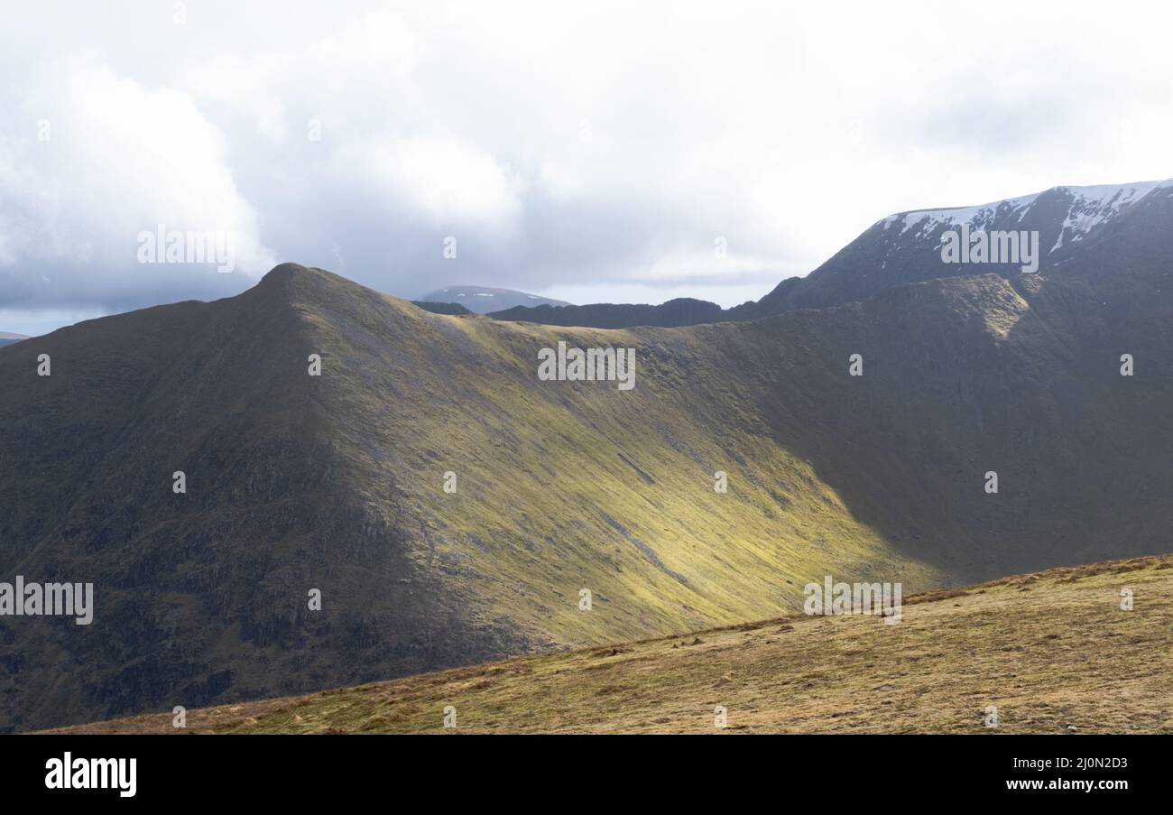 Ein Blick auf Catstye Cam, Helvellyn und Lower man, die alle im Lake District, Großbritannien, immer noch mit Schnee bedeckt sind Stockfoto