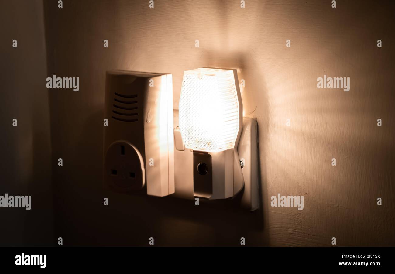 Nahaufnahme eines Nachtlichts, das an eine Wand in einem Haus angeschlossen ist Stockfoto