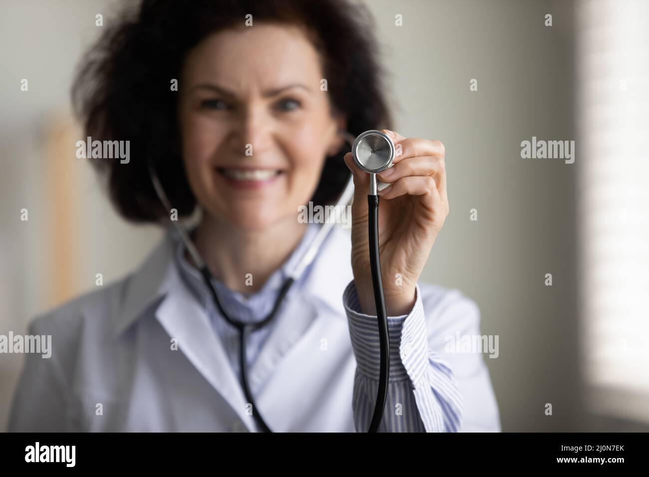 Glückliche, freundliche Ärztin, die medizinische Untersuchungen fördert Stockfoto