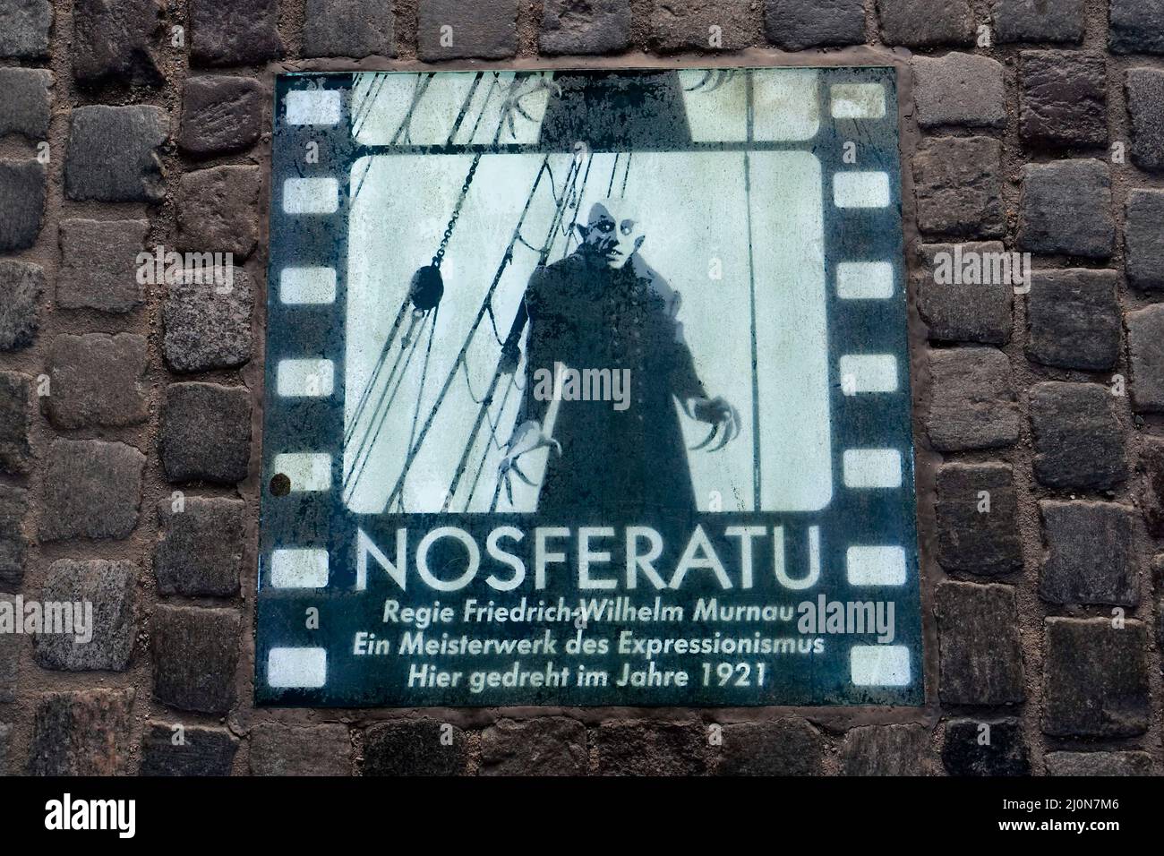DEUTSCHLAND, Wismar an der Ostsee, Gedenktafel für den deutschen Klassiker Nosferatu von Friedrich-Wilhelm Murnaus am alten hanseatic Wassertor am Hafen, Teile des Stummfilms wurden 1921 in der historischen Altstadt gedreht, Das Thema des Films ist eine Vampirgeschichte, inspiriert durch das Buch Dracula von Bram Stoker / DEUTSCHLAND, Wismar, die historische Altstadt ist UNESCO Welterbe, Wassertor am Spiegelberg am Hafen, Infotafel zum deutschen Film Nosferatu, hier wurden 1921 Teile des Stummfilm Klassiker NOSFERATU von Friedrich-Wilhelm Murnau gedreht Stockfoto