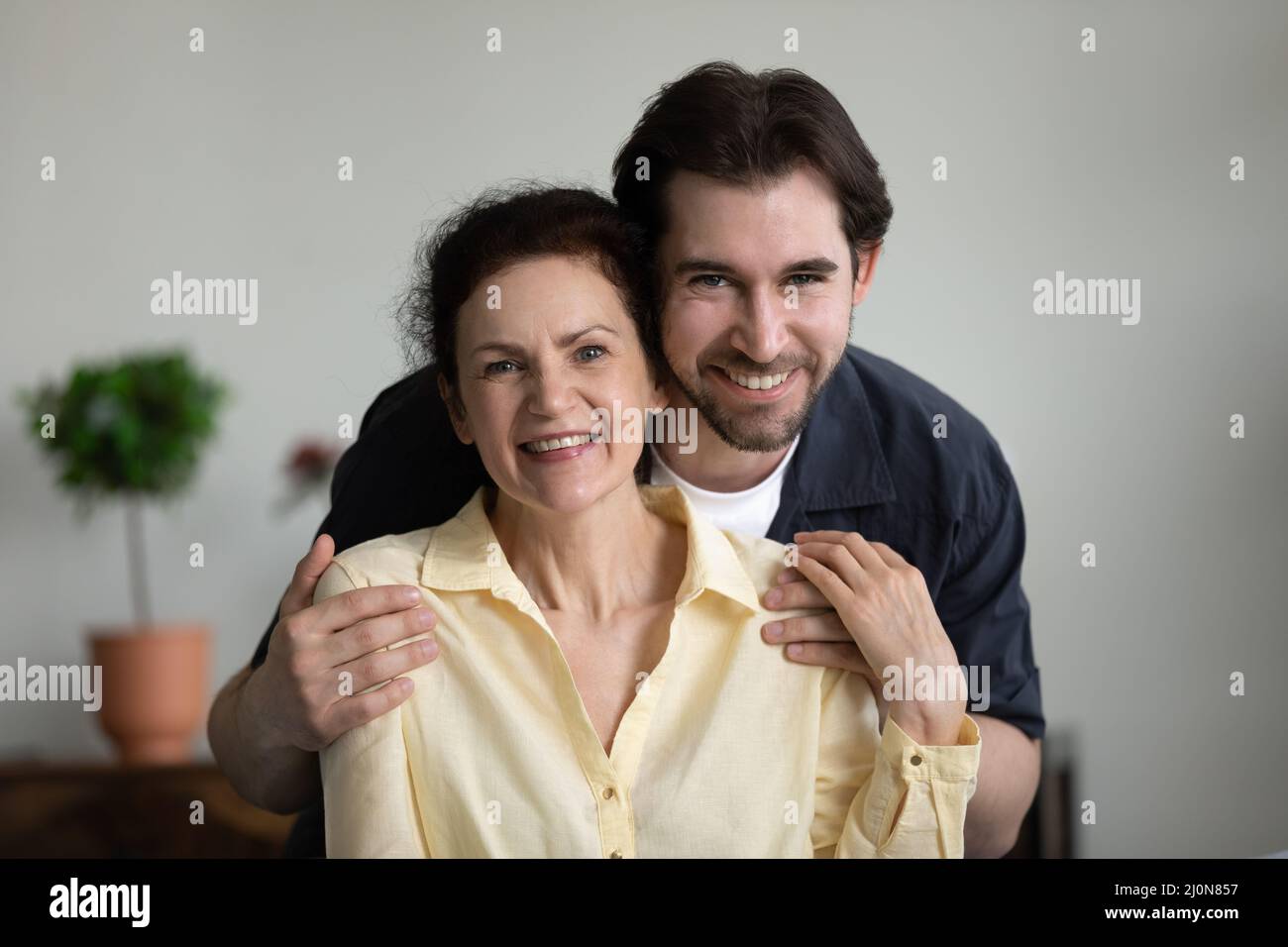 Dankbarer liebevoller erwachsener Sohn, der glückliche ältere Mutter mit Zärtlichkeit umarmt Stockfoto