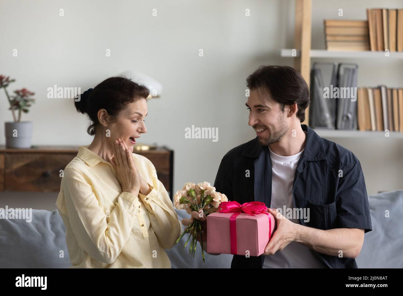 Glücklich aufgeregt reifen Mutter immer präsent und Blumen vom Sohn Stockfoto