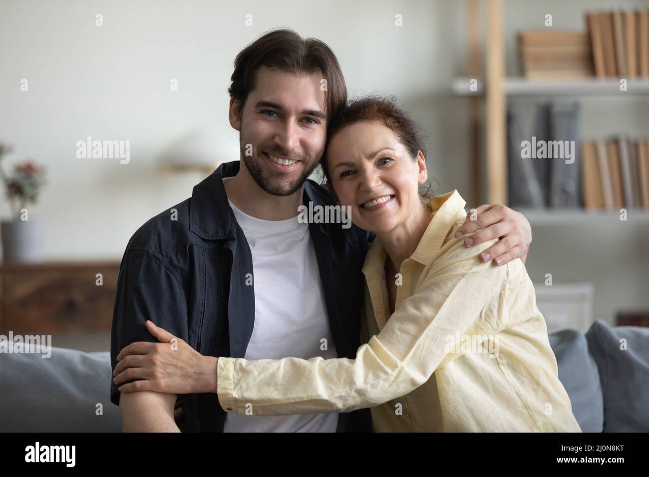 Glückliche Mutter und erwachsener Sohn mittleren Alters umarmten sich mit Zuneigung Stockfoto