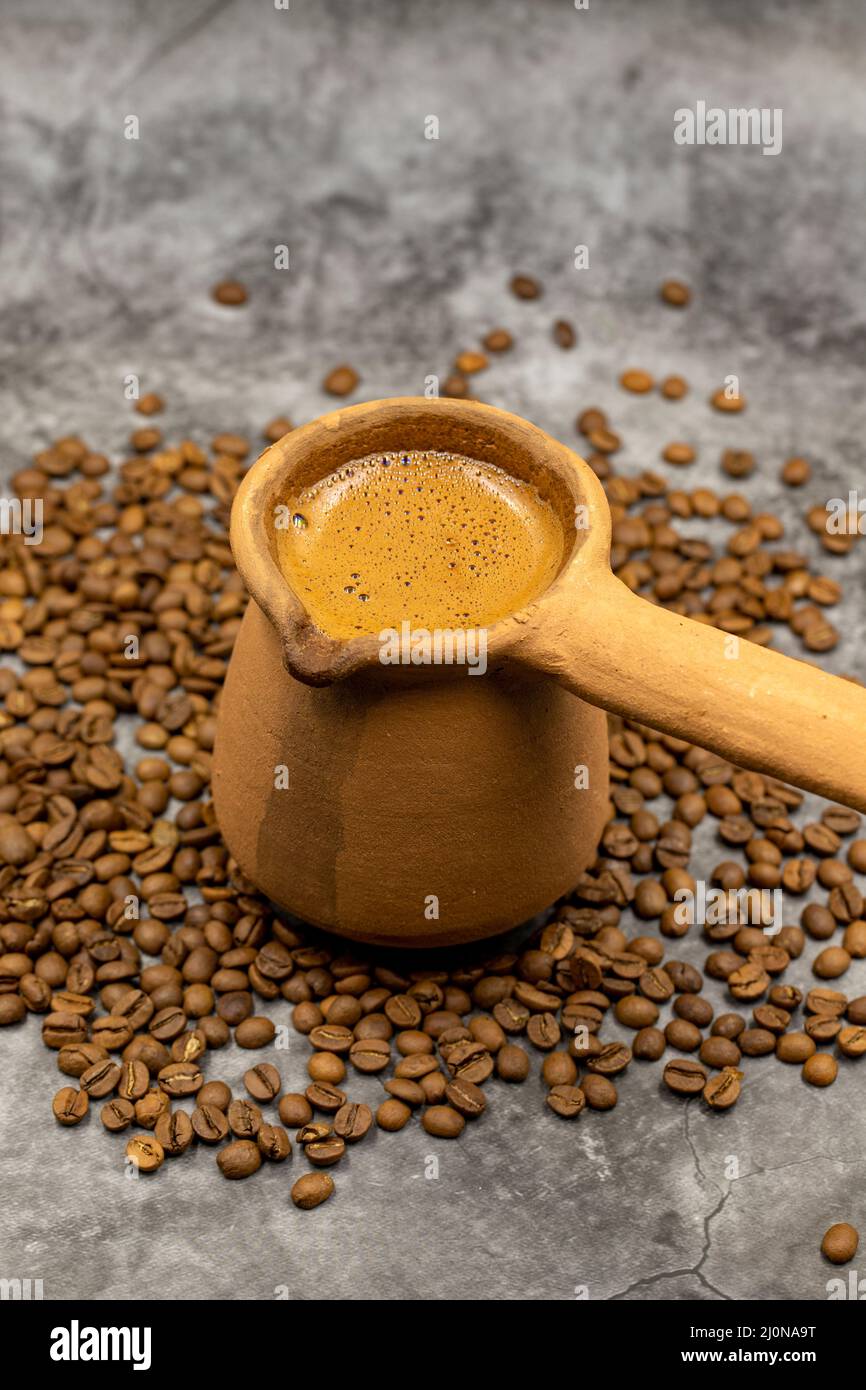 Türkischer Kaffee in einer irdenen Kanne auf dunklem Hintergrund. Nahaufnahme Stockfoto