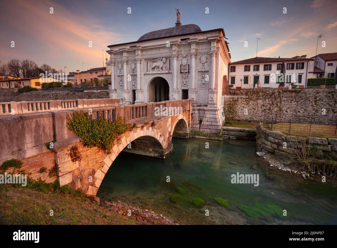 Treviso, Italien. Stadtbild von Treviso, Italien mit Tor zur Altstadt bei Sonnenuntergang. Stockfoto