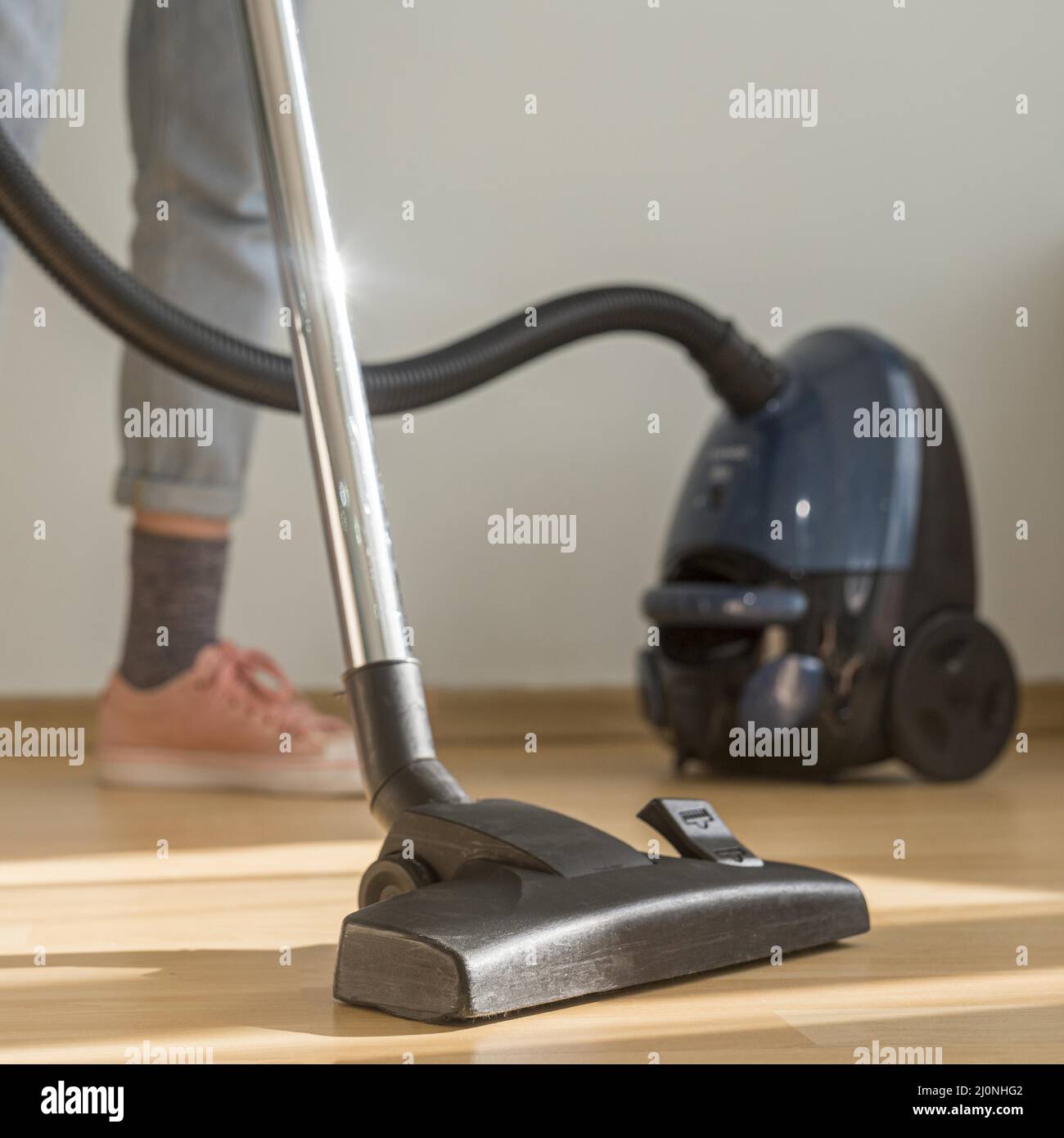 Frau, die den Raum mit Staubsauger putzt. Hohe Qualität und Auflösung schönes Fotokonzept Stockfoto