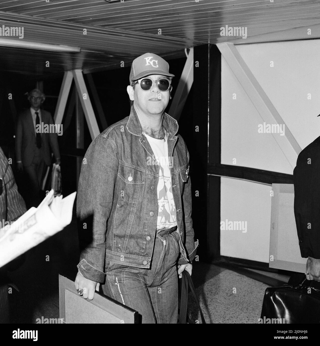 Sänger Elton John kommt aus Australien am Flughafen Heathrow an, wo er Cricket beobachtet hat. 7.. Februar 1983. Stockfoto