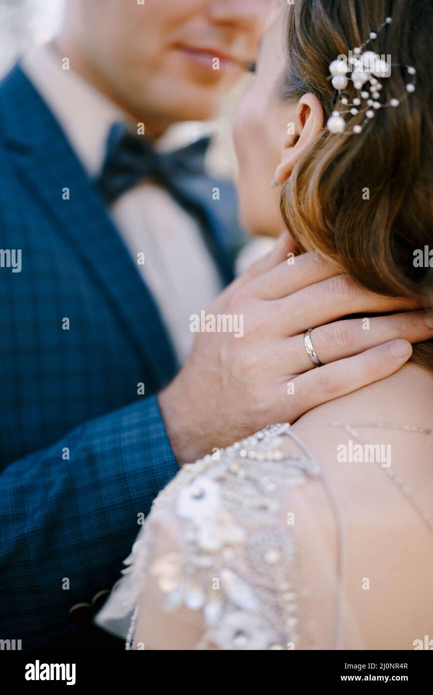 Bräutigam berührt den Brauthals mit der Hand. Rückansicht. Nahaufnahme Stockfoto