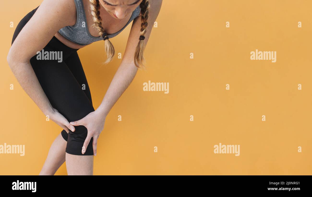 Frau Sportbekleidung berührt verletzendes Knie. Hohe Qualität und Auflösung schönes Fotokonzept Stockfoto