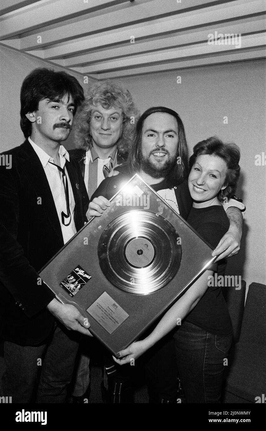 Midland-Popstars Slade haben £385 aufgesetzt, als sie auf dem Saturday Starship von Central TV auftraten und eine goldene Disc-Kopie von Slades Smash Hits versteigert, als sie den äthiopischen Hungeraufruf unterstützt haben. Slades Dave Hill und Noddy Holder sind mit Fan Frances Tucker aus Rushden abgebildet. 1.. Dezember 1984. Stockfoto