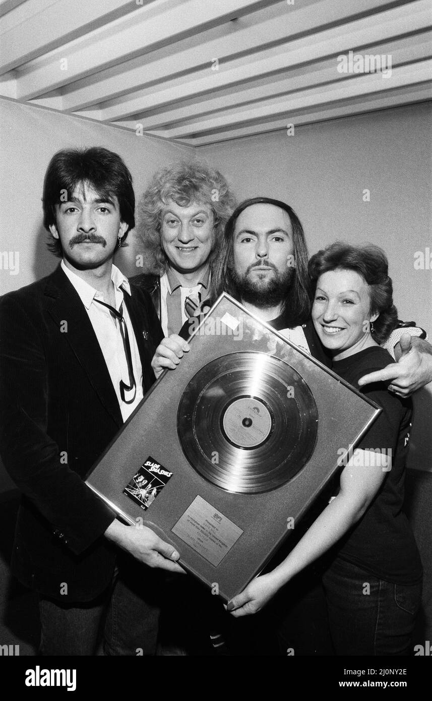 Midland-Popstars Slade haben £385 aufgesetzt, als sie auf dem Saturday Starship von Central TV auftraten und eine goldene Disc-Kopie von Slades Smash Hits versteigert, als sie den äthiopischen Hungeraufruf unterstützt haben. Slades Dave Hill und Noddy Holder sind mit Fan Frances Tucker aus Rushden abgebildet. 1.. Dezember 1984. Stockfoto