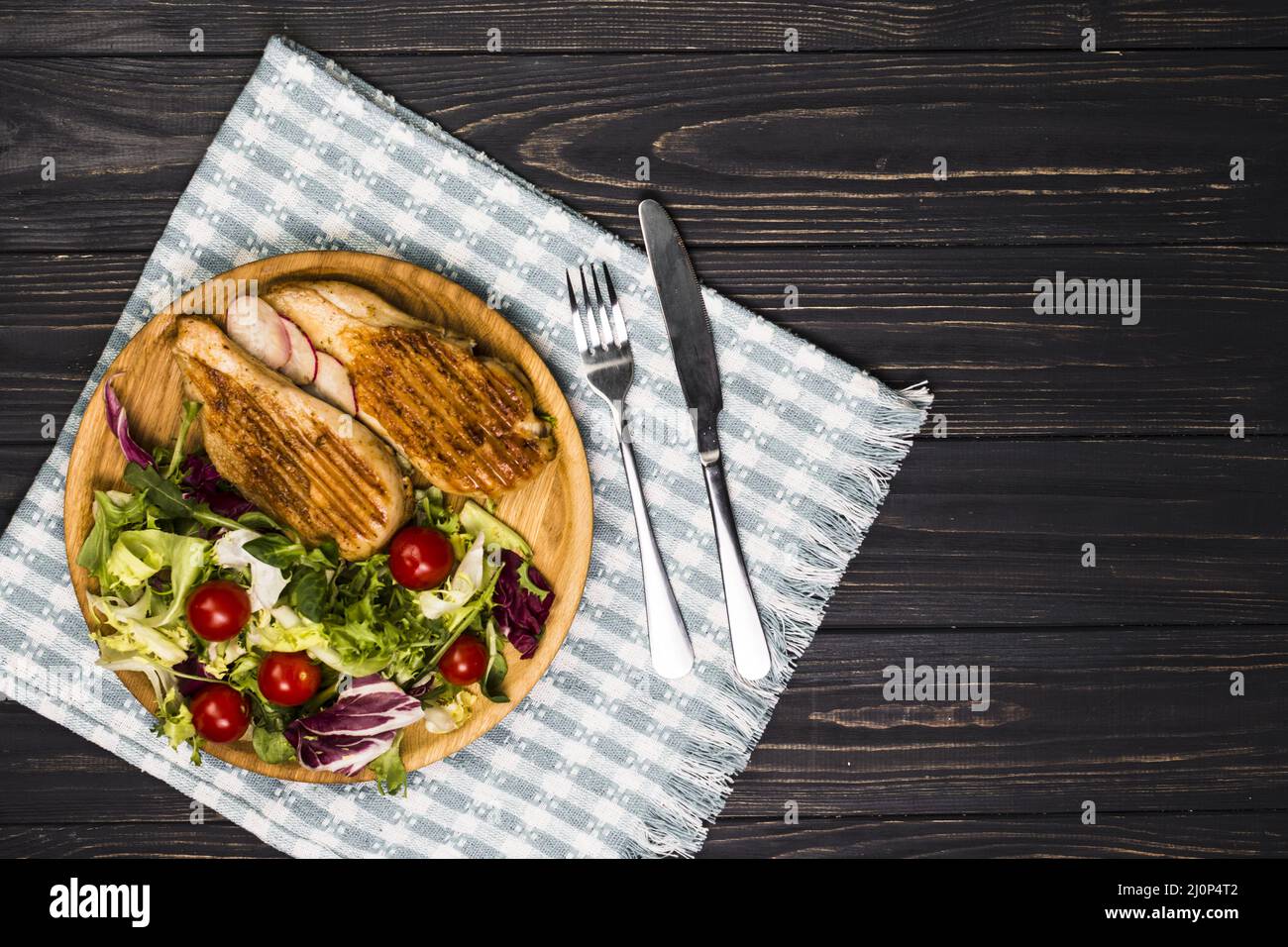 Utensilien in der Nähe von gebratenem Huhn und Salat. Hohe Qualität und Auflösung schönes Fotokonzept Stockfoto