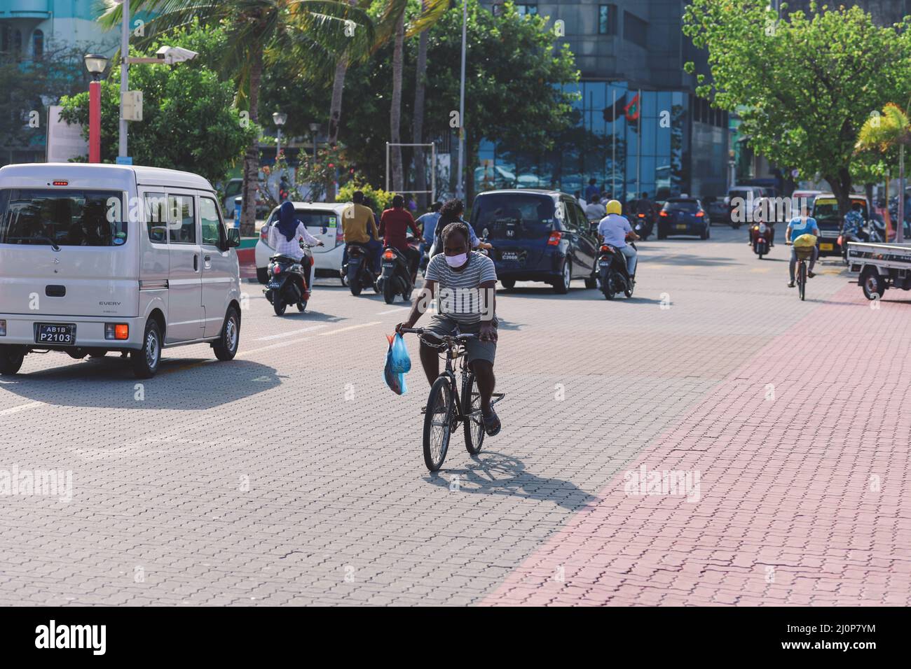 Maledivische Einheimische fahren auf den Bikes auf den Straßen von Male City Stockfoto