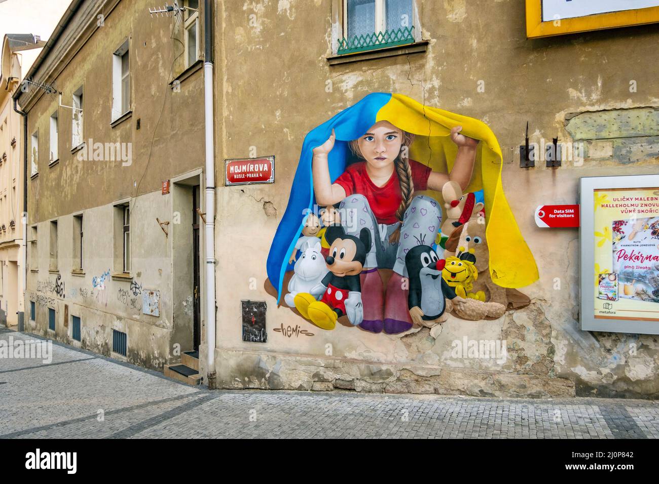 Ein Mädchen, das unter ukrainischer Flagge Schutz nimmt, Wandgemälde von ChemiS (tschechischer Künstler mit kasachischen Wurzeln, Dmitri Proshkin), Nusle, Prag, Tschechische republik Stockfoto