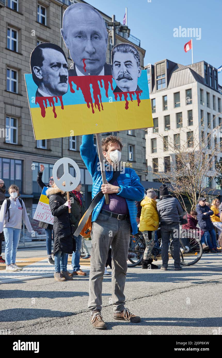 Hamburg, Deutschland. 20. März 2022. Ein Teilnehmer der Demonstration "Frieden in der Ukraine - Sicherheit in Europa" auf dem Jungfernstieg hält ein Banner mit den Ähnlichkeiten von Hitler, Putin und Stalin. Quelle: Georg Wendt/dpa/Alamy Live News Stockfoto