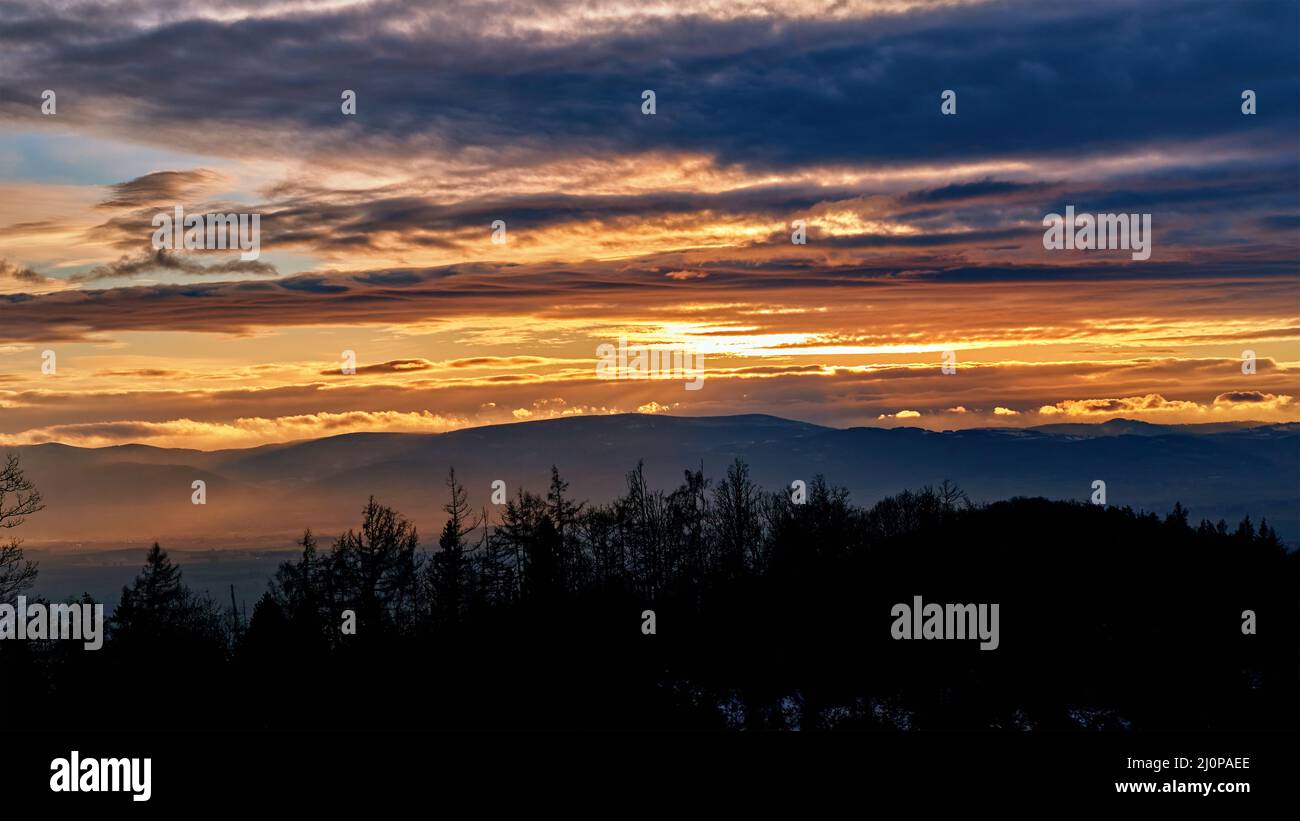 Sonnenuntergang mit dramatisch bewölktem Himmel über Bergen Form, schöne Naturlandschaft Stockfoto