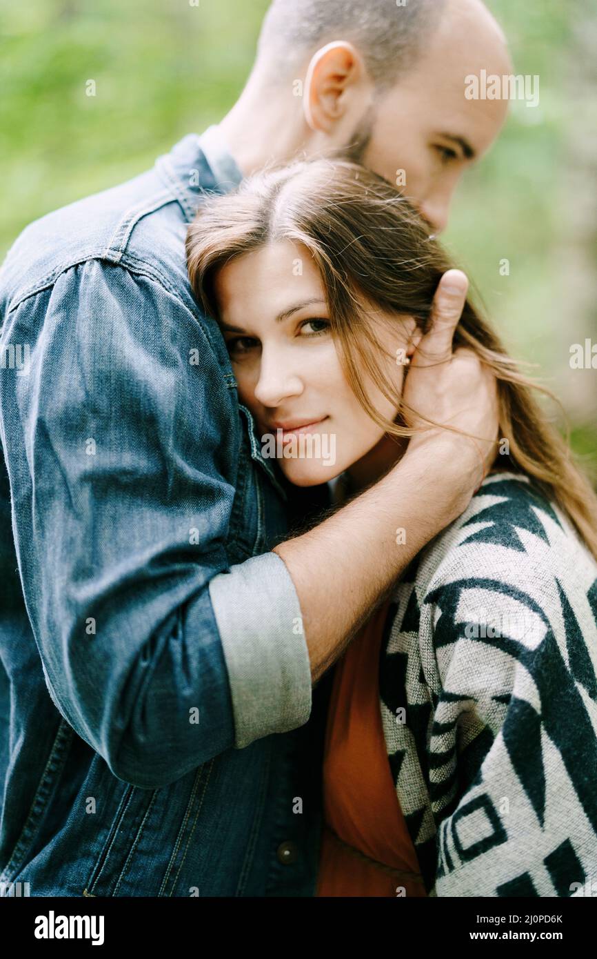 Mann umarmt Frau im Park. Hochformat Stockfoto