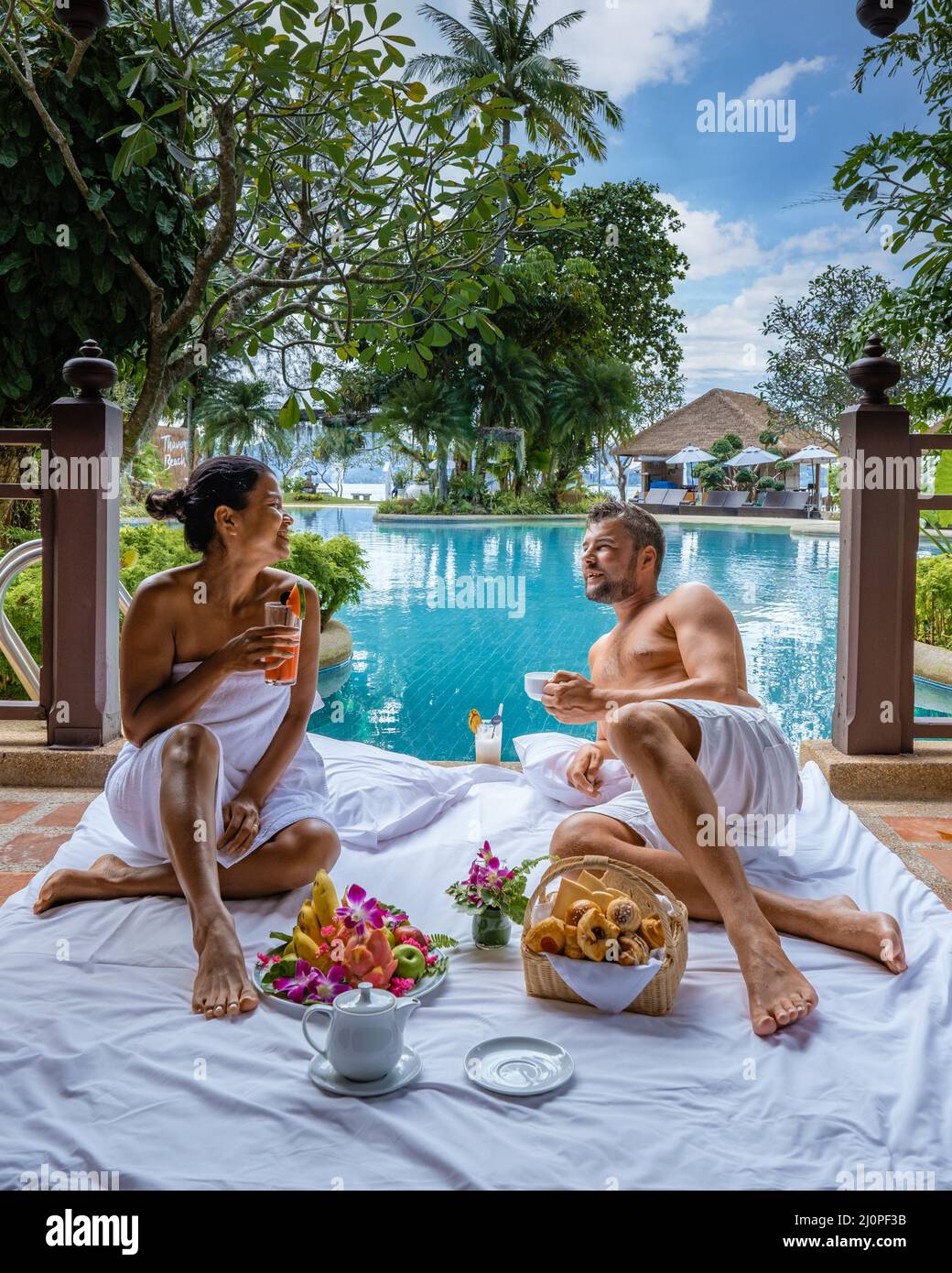Wir frühstückten ein Paar am Pool, Mann und Frau sind im Urlaub in Thailand und haben am Pool gefrühstückt Stockfoto