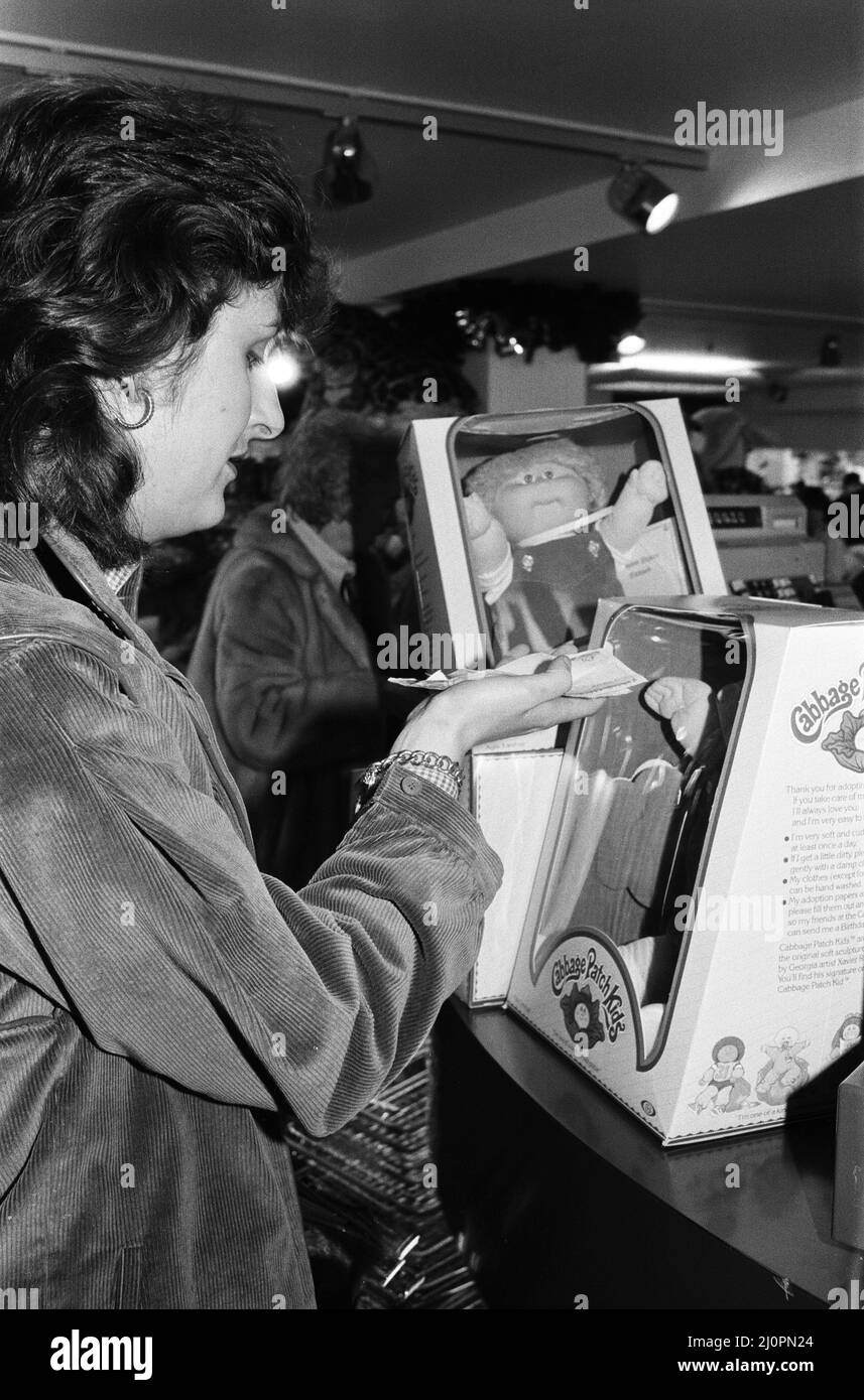 Kohl Patch Dolls zum Verkauf in Harrods. Ein glücklicher Kunde kauft zwei Kohlfleckpuppen. 1.. Dezember 1983. Stockfoto
