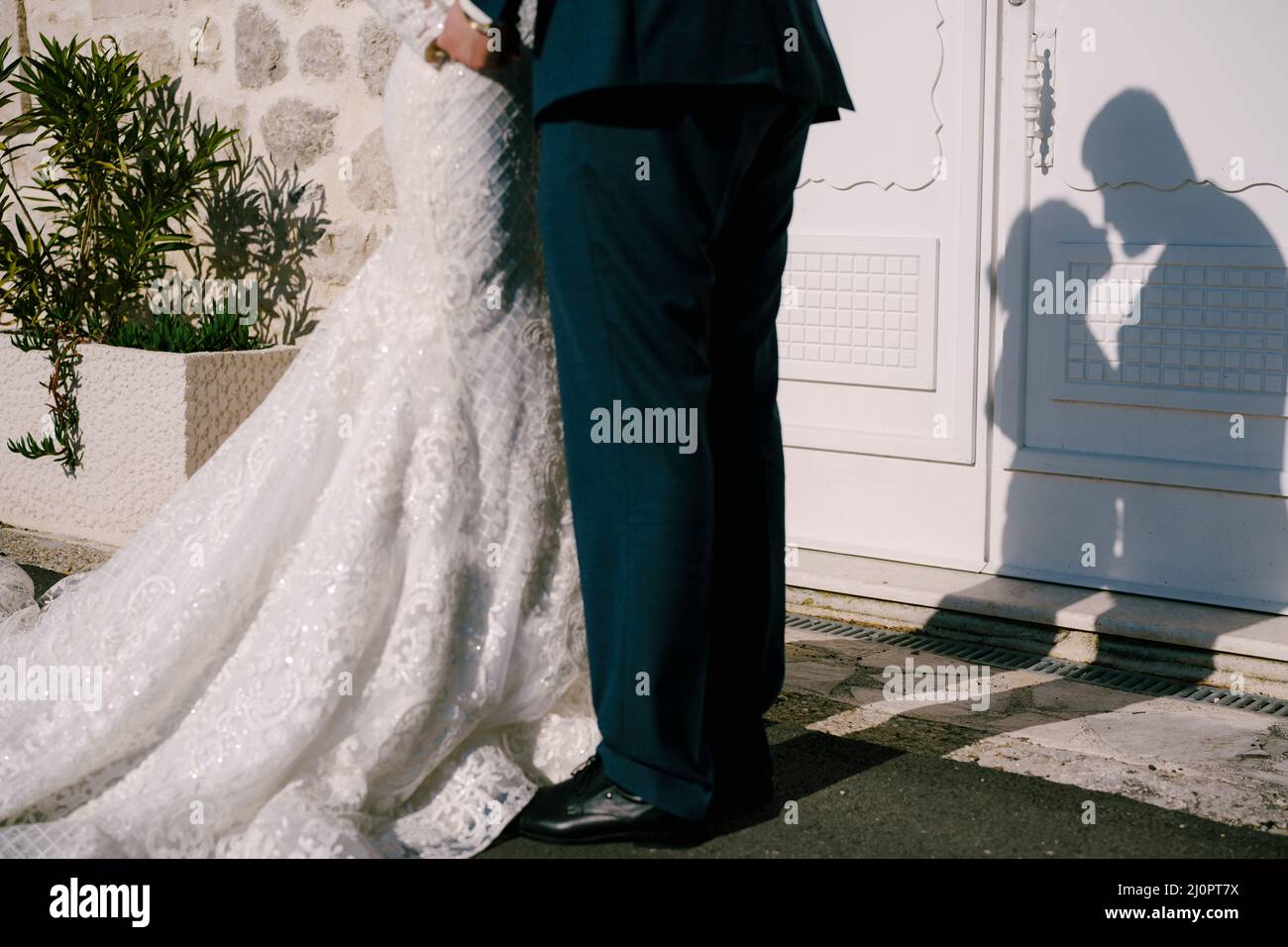 Schatten von fast küssenden Braut und Bräutigam an der Tür des Steinhauses. Nahaufnahme Stockfoto