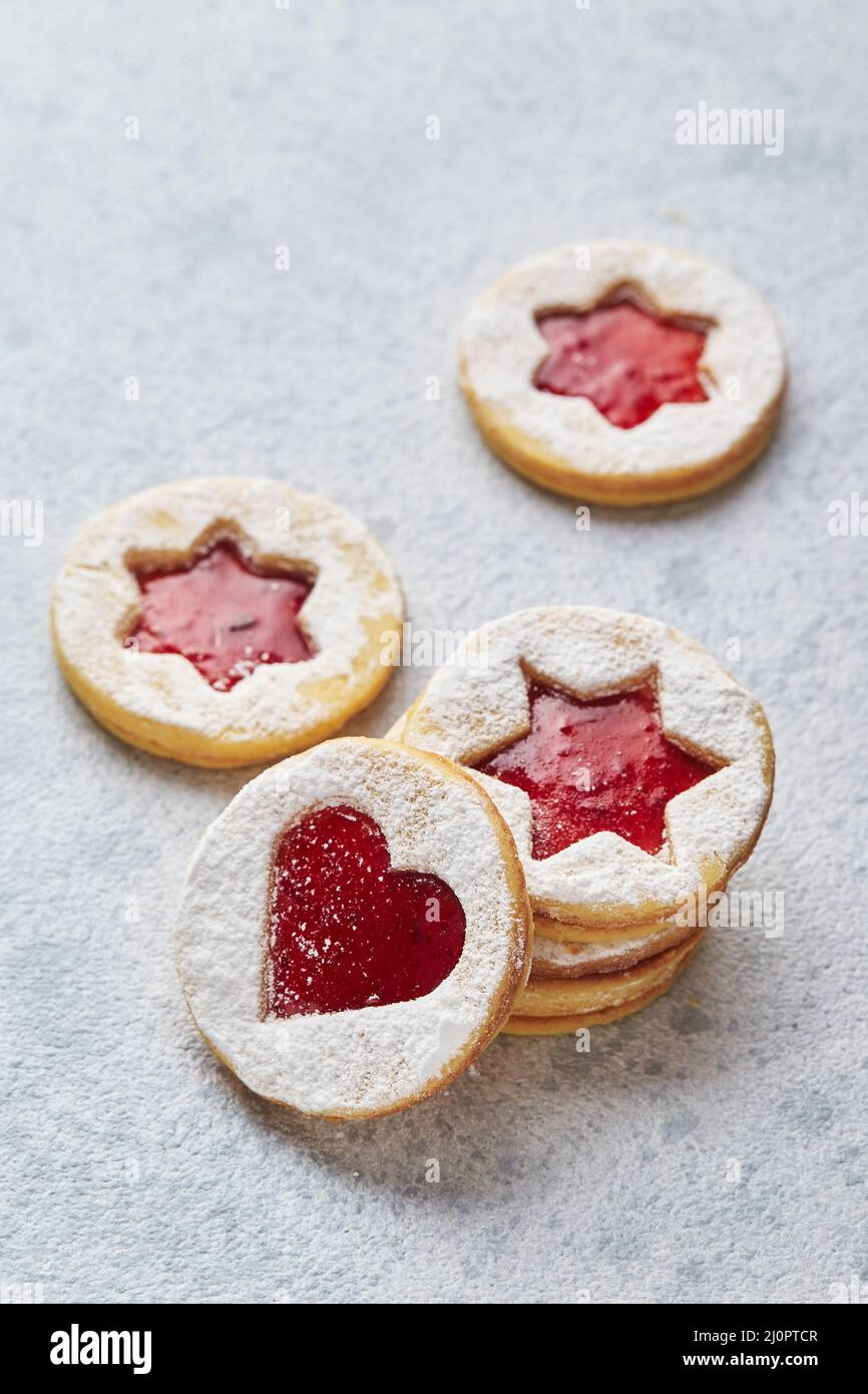 Klassische Linzer Weihnachtsplätzchen mit Himbeer- oder Erdbeermarmelade auf hellem Hintergrund. Stockfoto