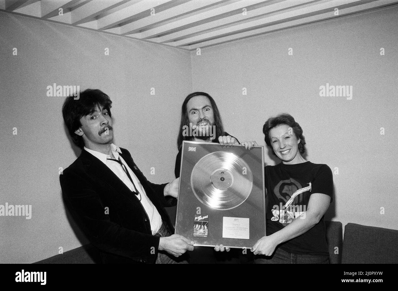 Midland-Popstars Slade haben £385 aufgesetzt, als sie auf dem Saturday Starship von Central TV auftraten und eine goldene Disc-Kopie von Slades Smash Hits versteigert, als sie den äthiopischen Hungeraufruf unterstützt haben. Slades Dave Hill ist mit Fan Frances Tucker aus Rushden abgebildet. 1.. Dezember 1984. Stockfoto
