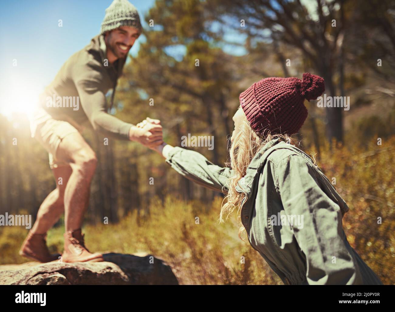 Und ihr eine Hand geben. Kurzer Shot eines jungen Paares beim Wandern. Stockfoto