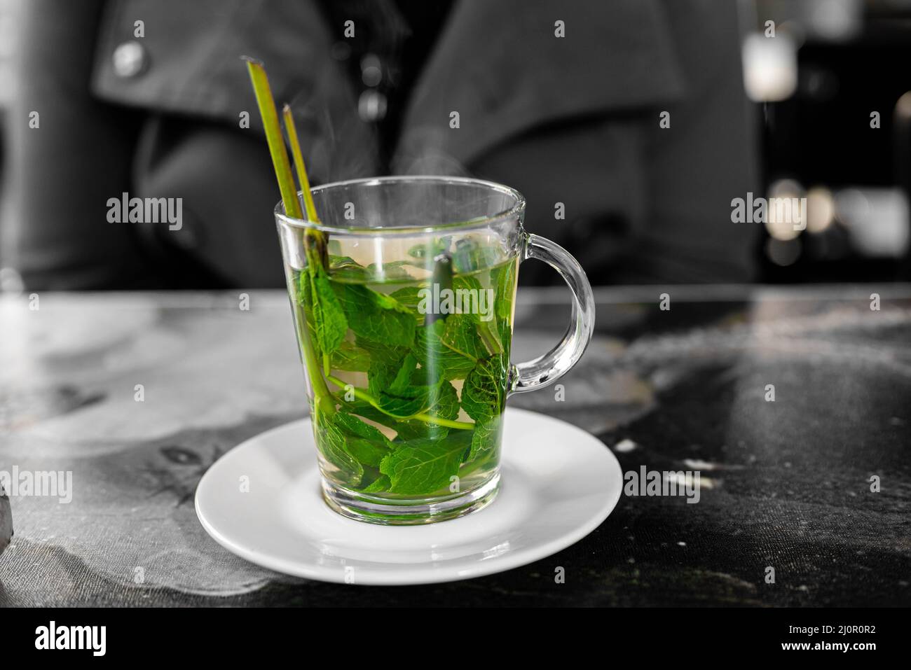 Frischer Minztee mit Honig wird in einem Restaurant auf einem Teller serviert Stockfoto