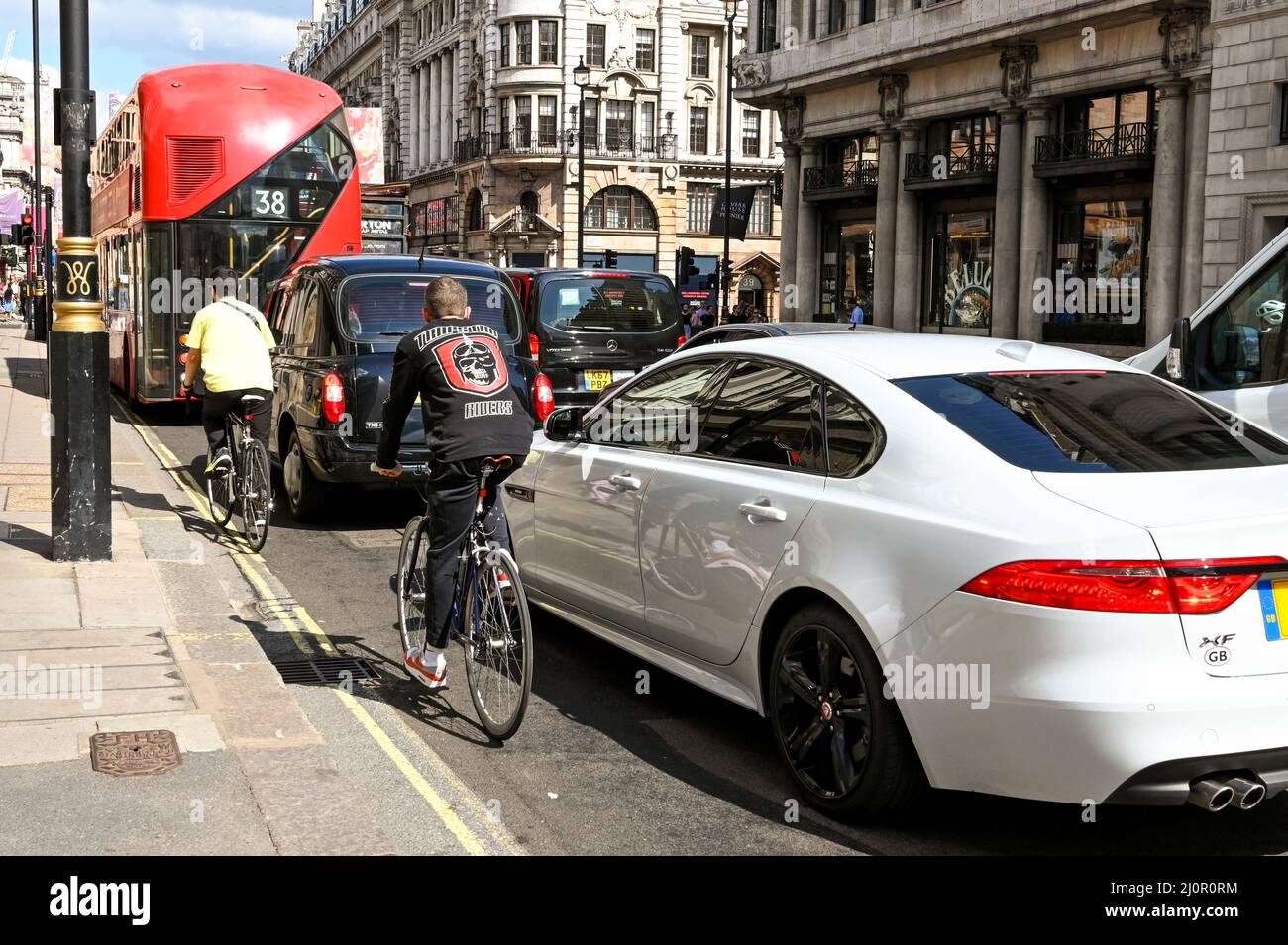 London, England - 2021. August: Radfahrer fahren auf einer Straße im Zentrum Londons entlang des anstehenden Verkehrs Stockfoto