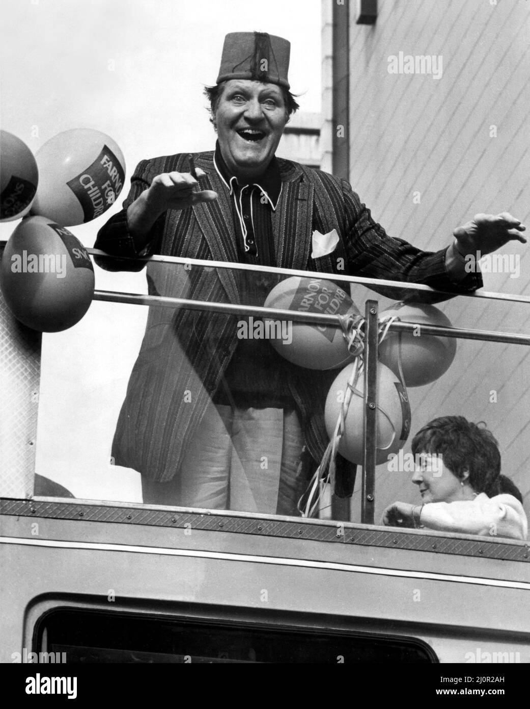 Der Komiker Tommy Cooper machte eine offene Busreise durch die Straßen von Newcastle. Die Reise wurde vom Kaufhaus Farnons organisiert, dessen Verkauf eröffnet werden sollte. Eine traditionelle Jazzband ritt mit ihm, um die Aufmerksamkeit der Menschen zu erregen. Dann überreichte Tommy den Gewinnern im Store Preise und signierte Autogramme für seine Fans - einfach so!. 2.. April 1983 Stockfoto