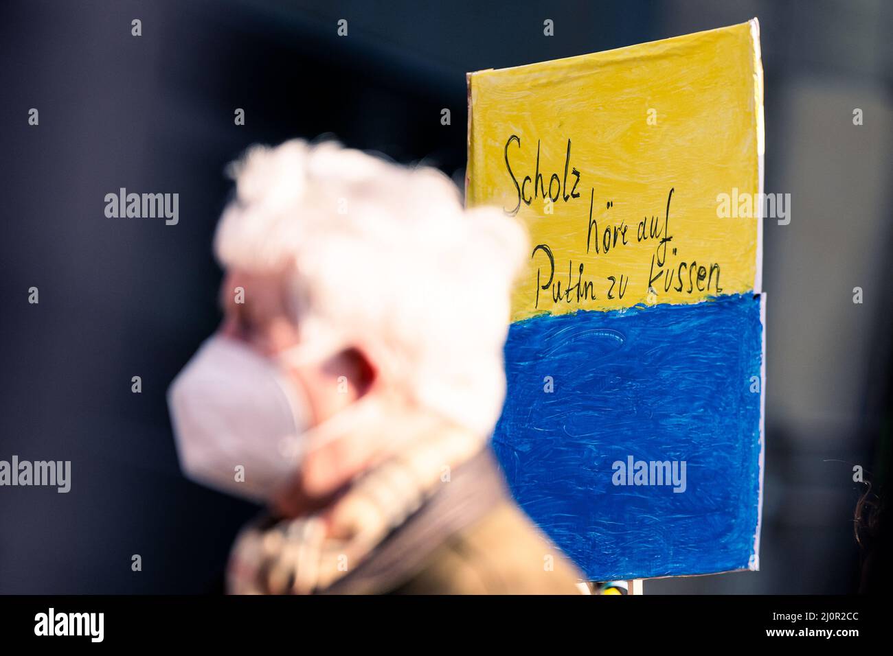 20. März 2022, Bremen: Ein älterer Mann steht während der Kundgebung gegen den Krieg in der Ukraine auf dem Domshof neben einem Schild mit der Aufschrift „Scholz hört auf, Putin zu küssen“. Foto: Mohssen Assanimoghaddam/dpa Stockfoto