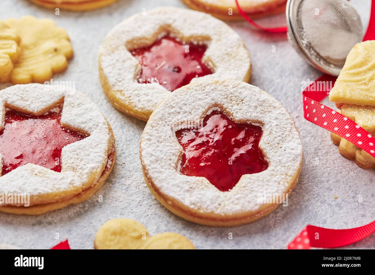 Klassische Linzer Weihnachtsplätzchen mit Himbeer- oder Erdbeermarmelade auf hellem Hintergrund. Stockfoto