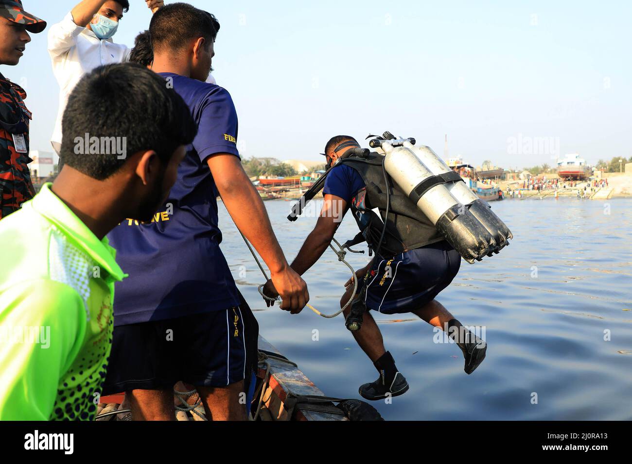 Narayanganj, Bangladesch. 20. März 2022. Taucher tauchen in den Fluss Shitalakshya in Narayanganj während der Rettungsaktion nach einem Start kenterte. Mindestens sechs Menschen starben und Dutzende bleiben vermisst, als ein Start kenterte, nachdem er am Sonntagnachmittag von einem Frachtschiff getroffen wurde. Kredit: SOPA Images Limited/Alamy Live Nachrichten Stockfoto