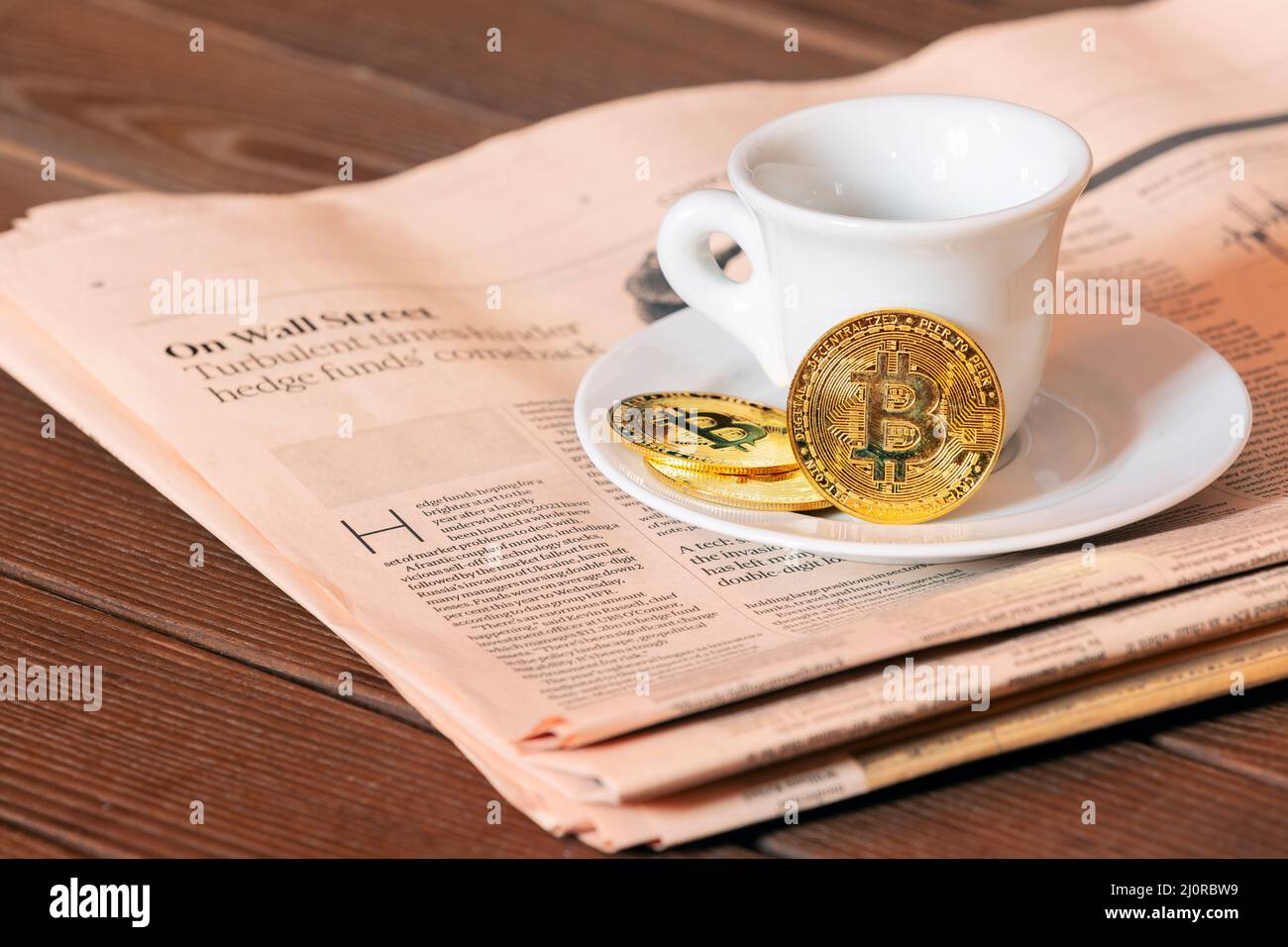 Morgenkaffee des Maklers an der Börse, schwarzer Kaffee und Bitcoin auf dem Hintergrund der Aktienkurskarte auf der Zeitung Stockfoto