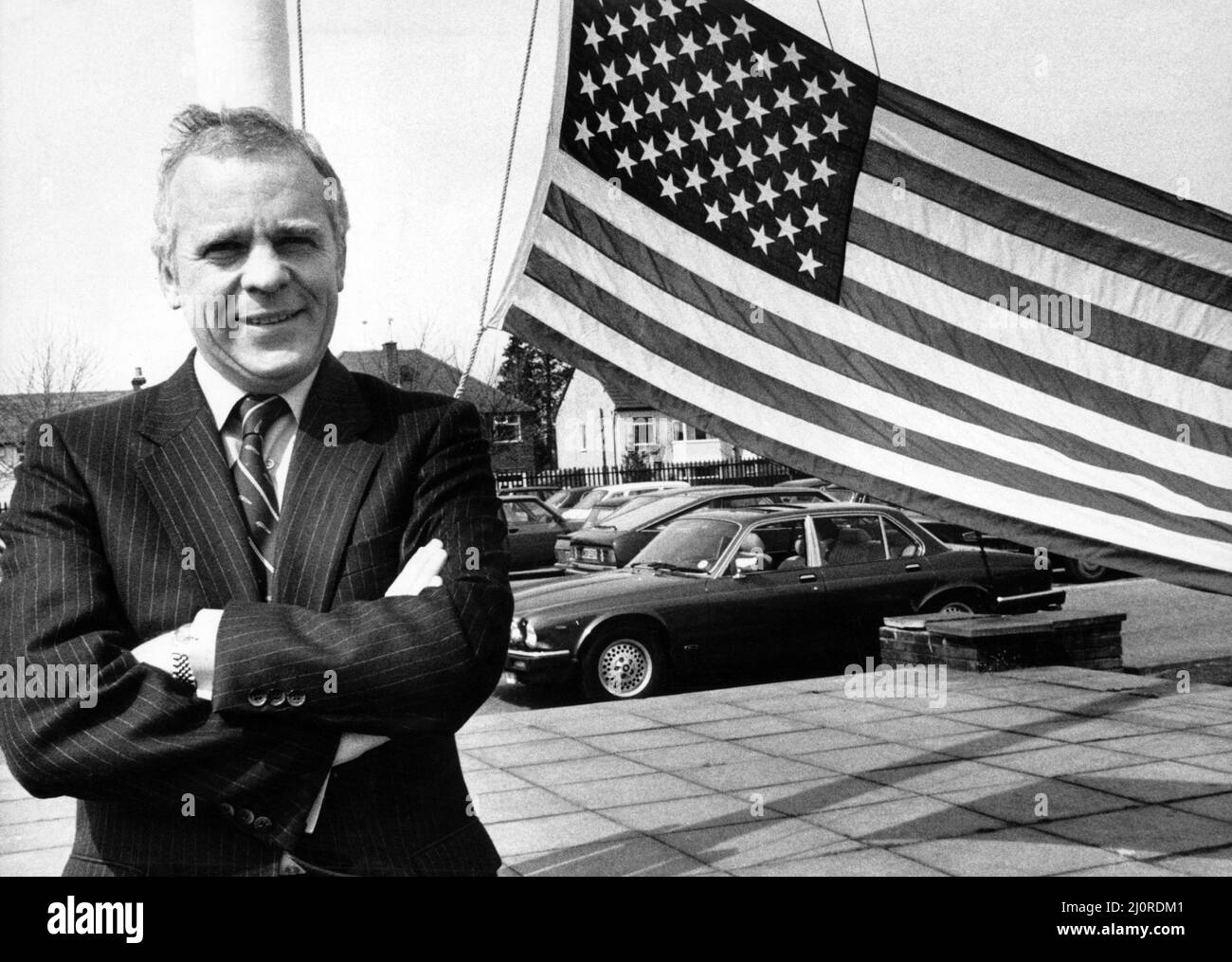 Jaguar Chairman John Egan hisste eine Jubiläumsflagge mit der Nachricht, dass Jaguar eine Auszeichnung gewonnen hat. 20.. April 1984. Stockfoto