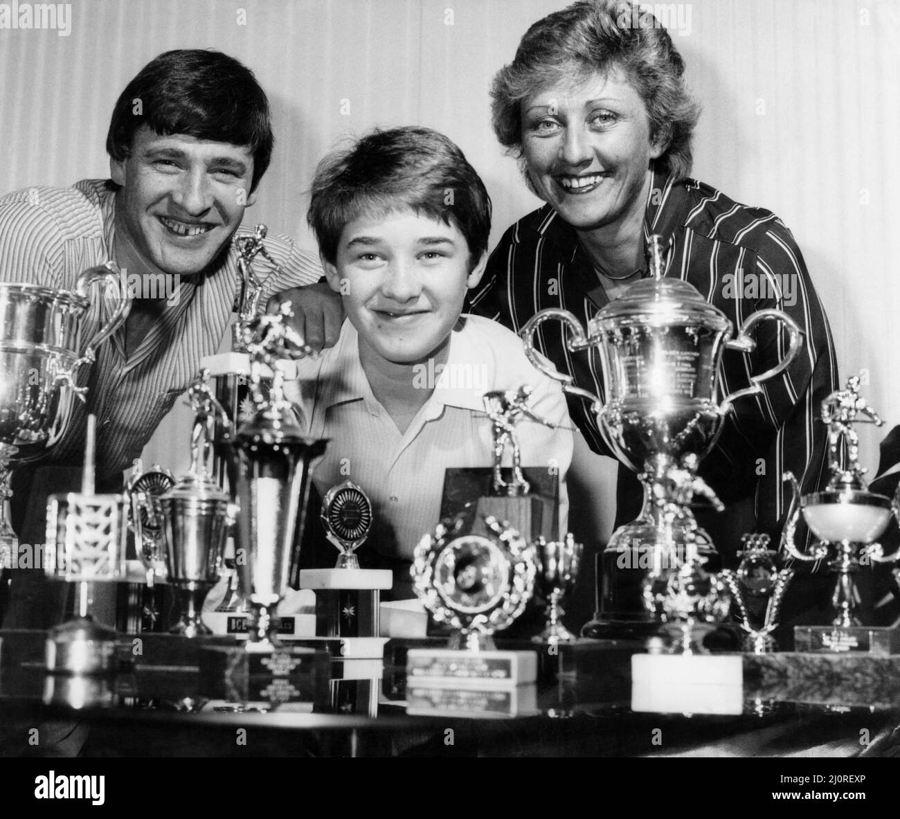 Stephen Hendry und seine stolzen Eltern posieren mit nur einigen seiner glitzernden Snooker-Trophäen-Sammlung.und der 15-jährige Queue-Zauberer aus Dalgety Bay, Fife, plant, in den kommenden Jahren noch einige zu sammeln. 16. Mai 1984 Stockfoto